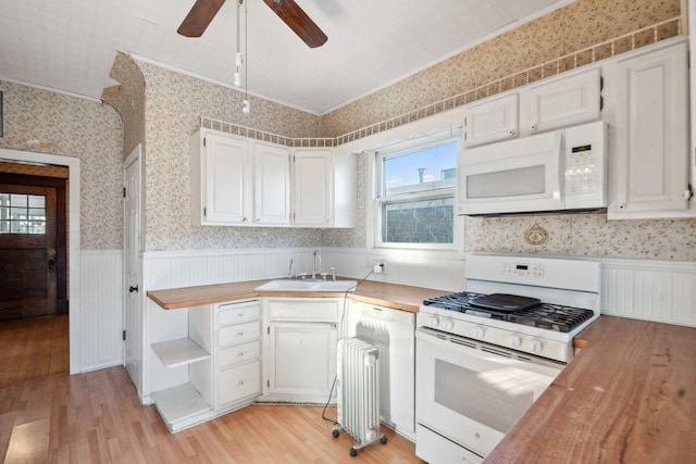 kitchen featuring butcher block countertops, sink, white cabinets, light hardwood / wood-style floors, and white appliances