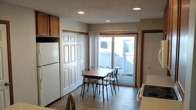 kitchen featuring white appliances, brown cabinetry, recessed lighting, and a textured ceiling