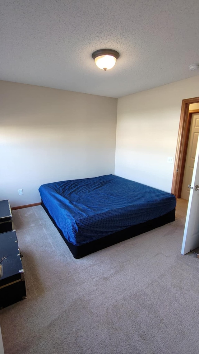 bedroom with carpet and a textured ceiling