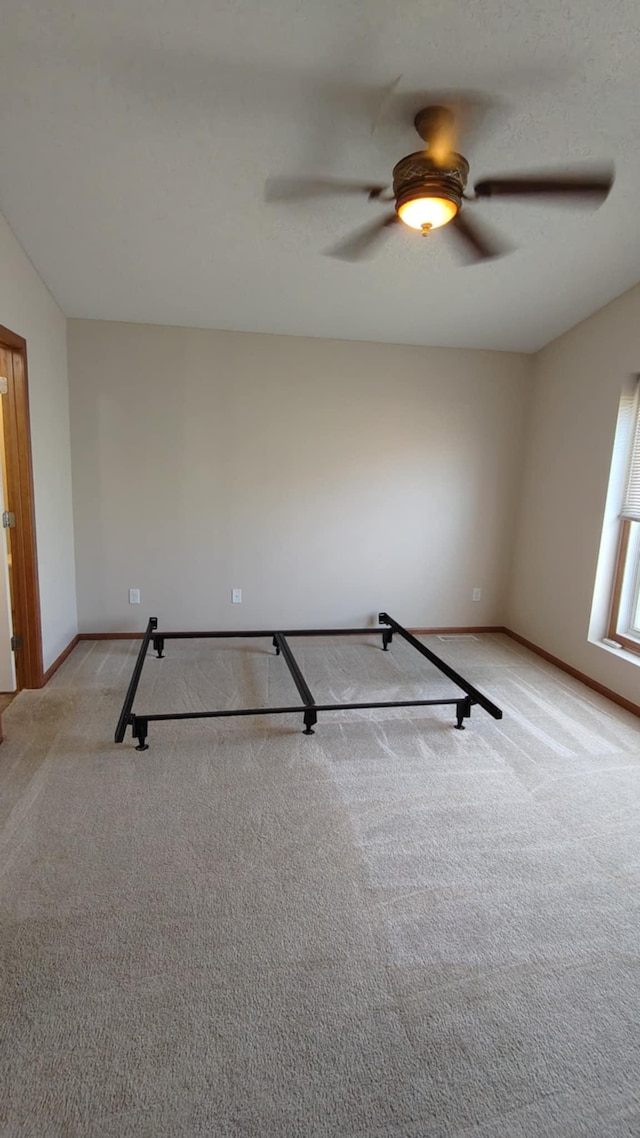 workout room featuring carpet flooring, baseboards, and a ceiling fan