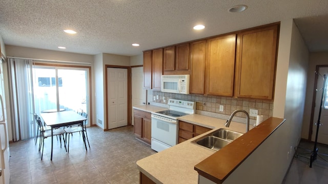 4970 149th St N Unit 3, Hugo, MN 55038 - kitchen featuring white appliances, a sink, recessed lighting, decorative backsplash, and a textured ceiling