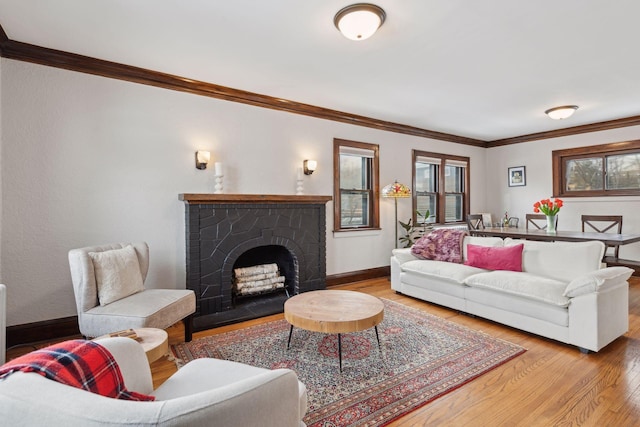 living room featuring crown molding, hardwood / wood-style flooring, and a fireplace