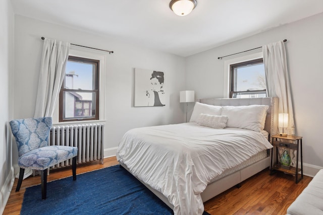 bedroom featuring radiator heating unit and dark hardwood / wood-style floors