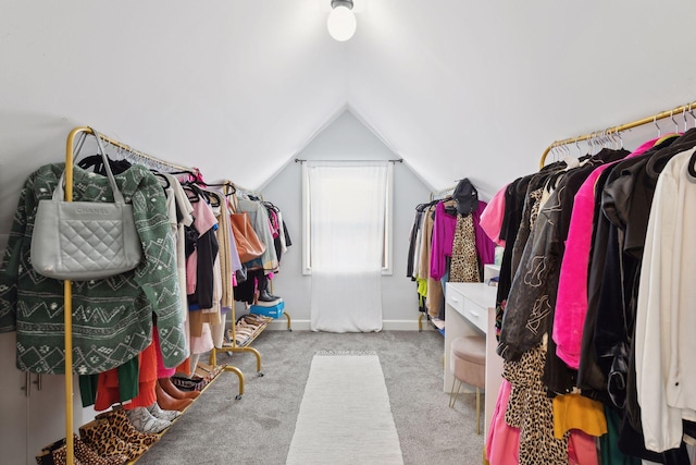 walk in closet with vaulted ceiling and carpet