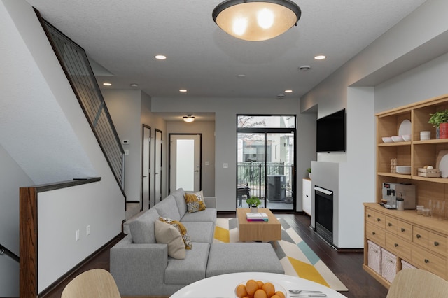 living room with dark hardwood / wood-style floors and a textured ceiling