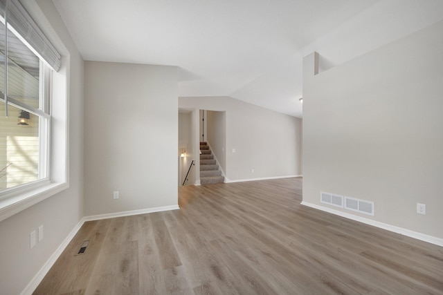 empty room featuring lofted ceiling and light hardwood / wood-style floors