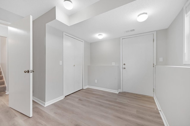 interior space with a textured ceiling and light wood-type flooring