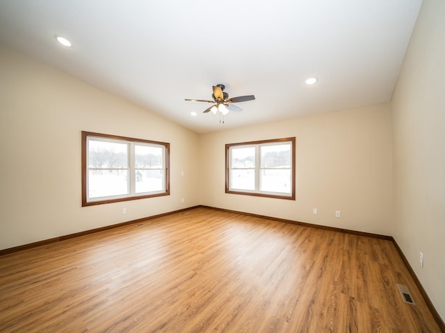 spare room with lofted ceiling, ceiling fan, and light wood-type flooring