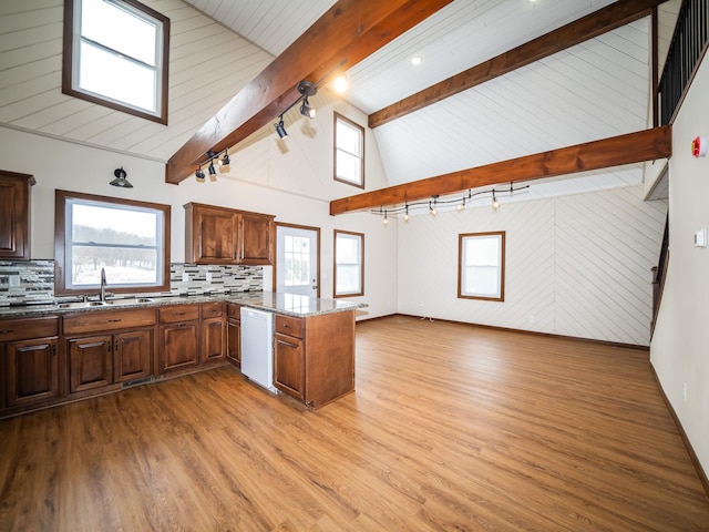 kitchen featuring dishwasher, sink, backsplash, and kitchen peninsula