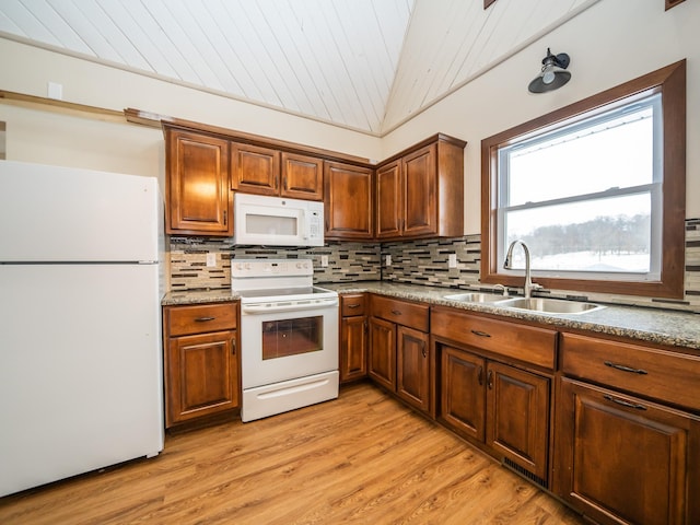 kitchen with tasteful backsplash, white appliances, lofted ceiling, and sink