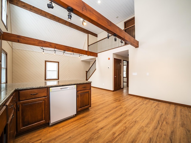 kitchen with dishwasher, light stone counters, track lighting, beamed ceiling, and light wood-type flooring