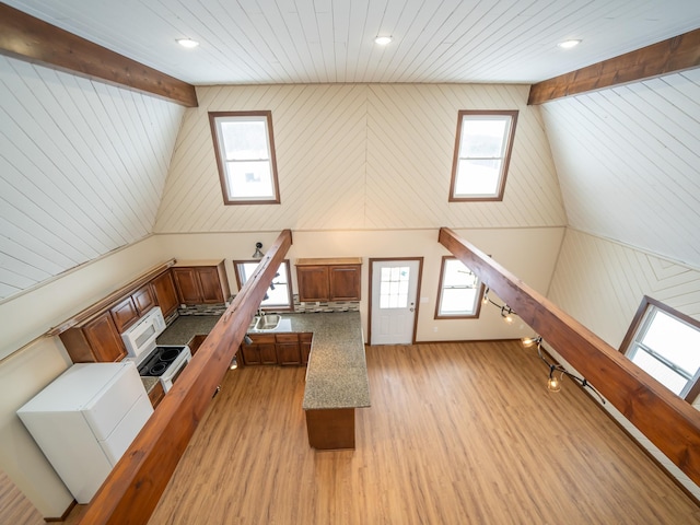 bonus room with beamed ceiling, a skylight, high vaulted ceiling, and light wood-type flooring