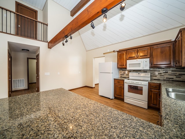 kitchen with beam ceiling, backsplash, white appliances, and light hardwood / wood-style flooring