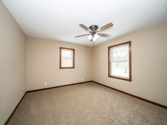 empty room with ceiling fan and carpet