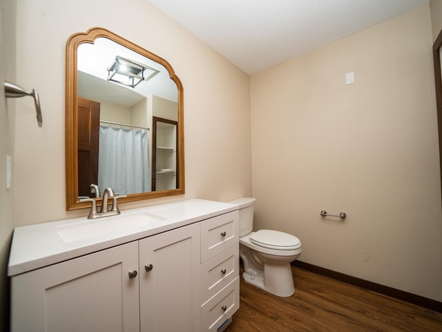 bathroom featuring vanity, toilet, and hardwood / wood-style floors