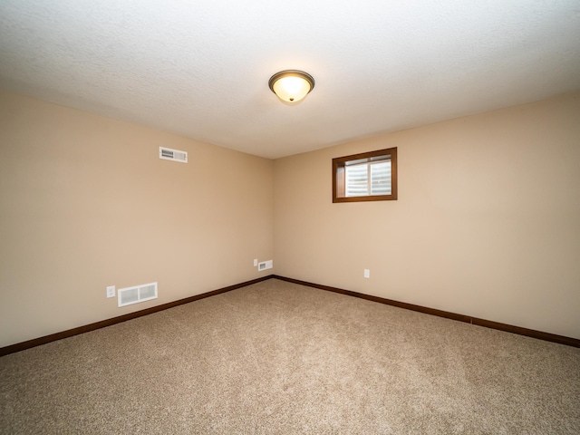 empty room featuring carpet flooring and a textured ceiling