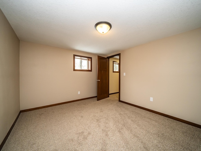 carpeted spare room featuring a textured ceiling