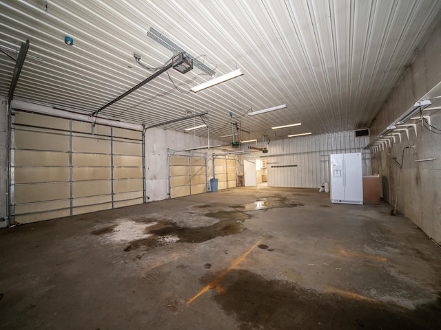 garage featuring a garage door opener and white fridge with ice dispenser