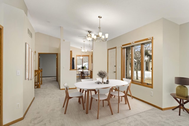 carpeted dining room featuring vaulted ceiling and an inviting chandelier