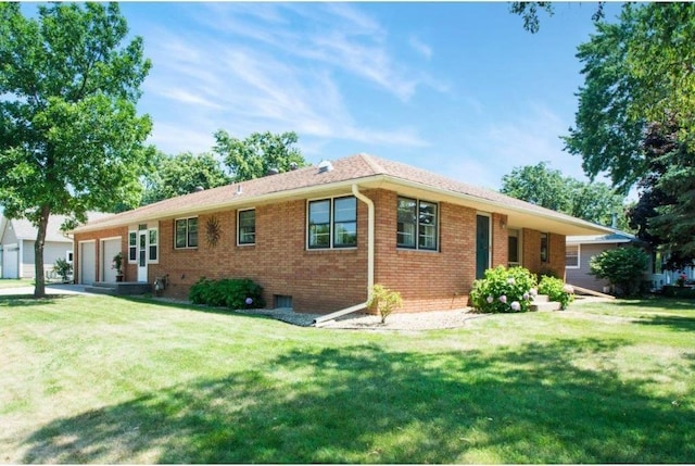 ranch-style house featuring a garage and a front lawn