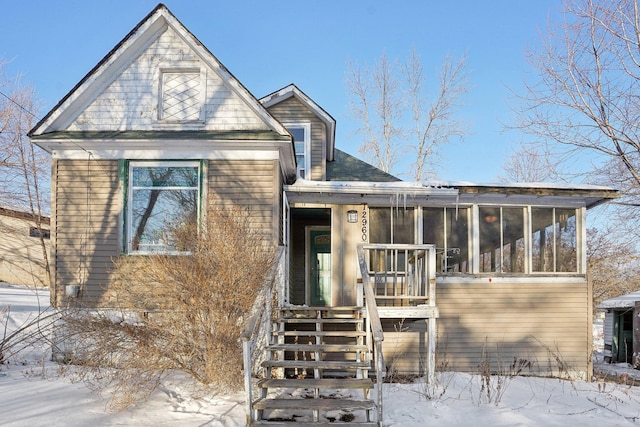 view of front of home featuring stairway and a sunroom