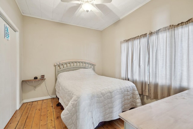 bedroom featuring multiple windows, ceiling fan, and wood finished floors