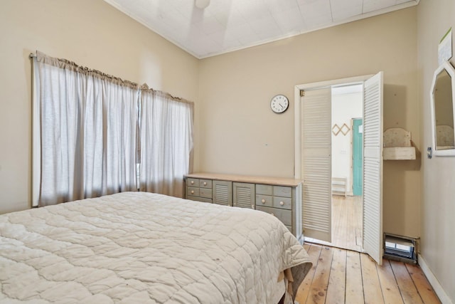 bedroom with light wood-style floors and ornamental molding