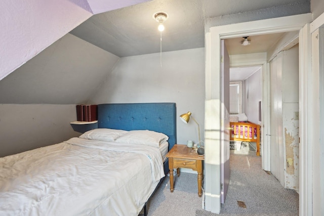 bedroom featuring lofted ceiling and carpet