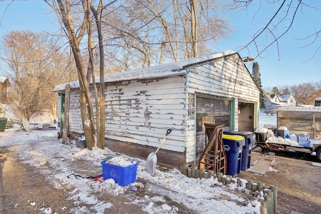 snow covered garage with a garage