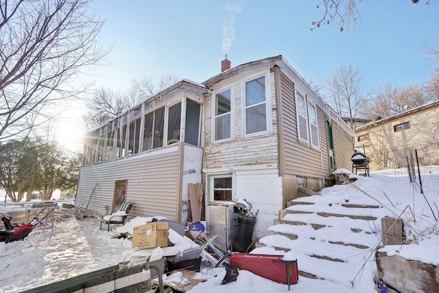 exterior space featuring a sunroom and a chimney