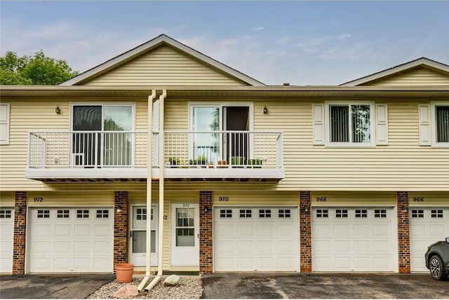 townhome / multi-family property featuring a balcony and a garage