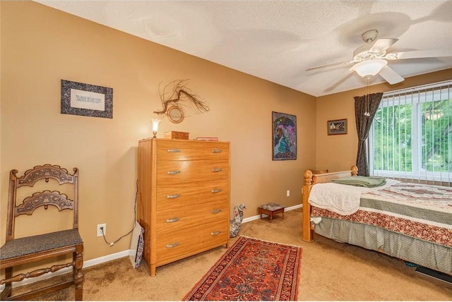 carpeted bedroom featuring a textured ceiling and ceiling fan