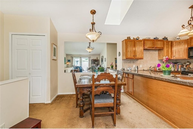 dining room featuring a skylight and light carpet