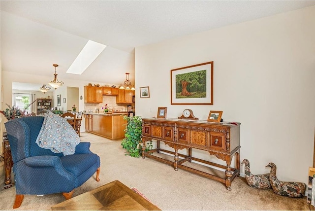 sitting room featuring light carpet and vaulted ceiling with skylight