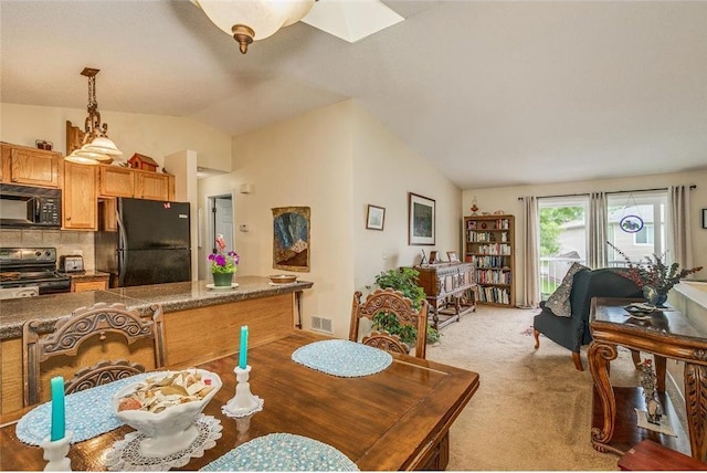 carpeted dining room with vaulted ceiling