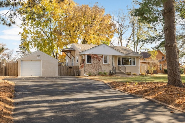 view of front of house with a garage, an outbuilding, and a front lawn