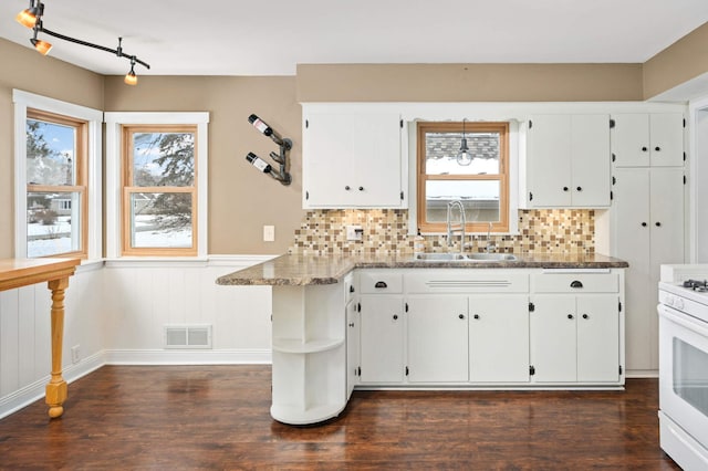 kitchen with sink, white cabinetry, and white gas stove