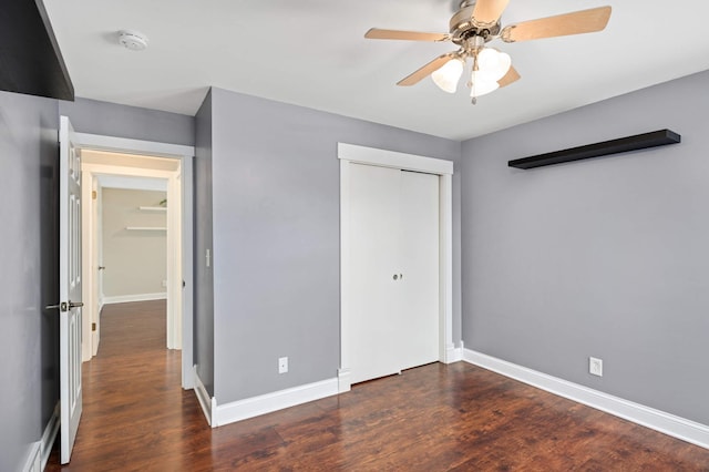 unfurnished bedroom featuring ceiling fan, a closet, and dark hardwood / wood-style flooring