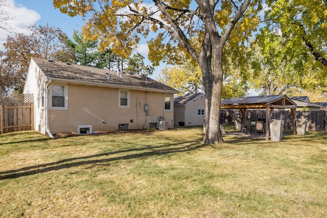 back of house featuring central AC unit, a yard, and a gazebo