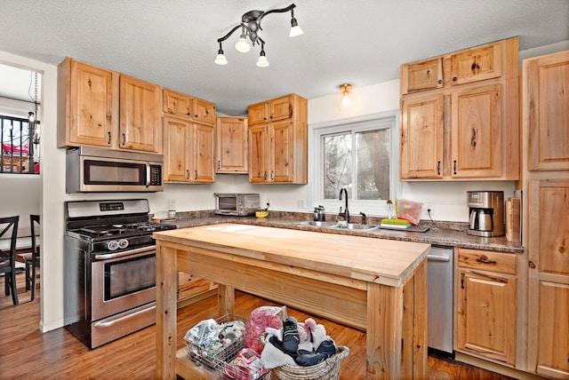 kitchen featuring stainless steel appliances, sink, a textured ceiling, and plenty of natural light