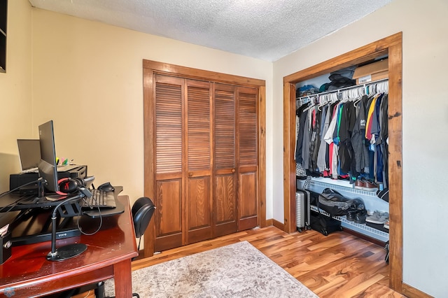 office area with light hardwood / wood-style flooring and a textured ceiling