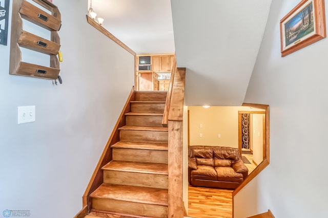 staircase with hardwood / wood-style floors