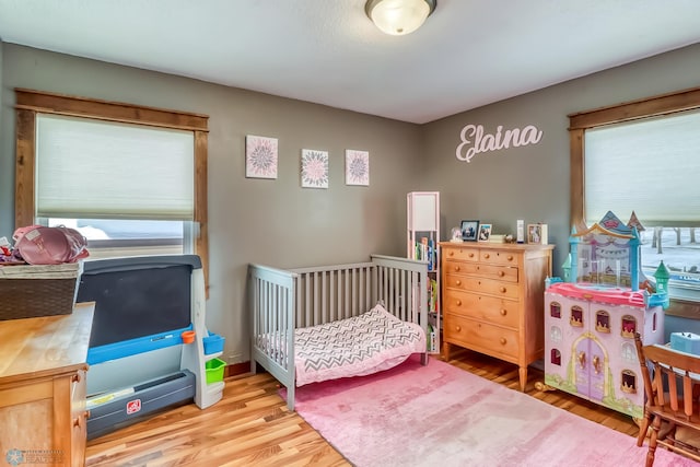 bedroom featuring hardwood / wood-style floors and multiple windows