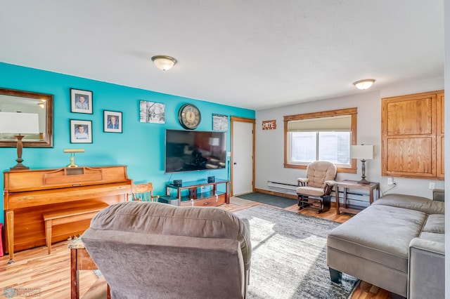 living room with a baseboard heating unit and light hardwood / wood-style flooring