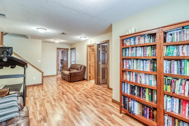 sitting room featuring a textured ceiling and light wood-type flooring