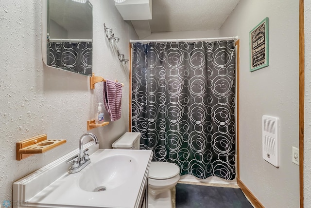 bathroom featuring vanity, a textured ceiling, toilet, and walk in shower