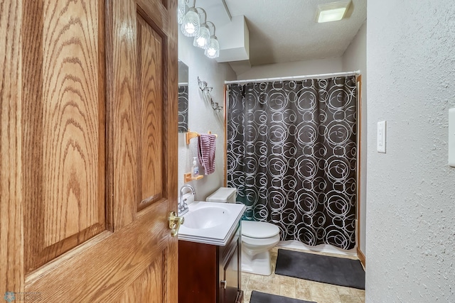 bathroom featuring vanity, curtained shower, a textured ceiling, and toilet