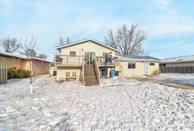 snow covered house with a wooden deck