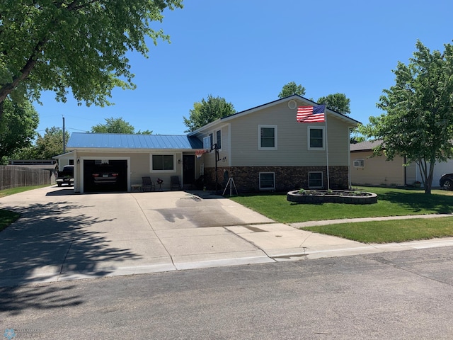 tri-level home featuring a garage and a front lawn