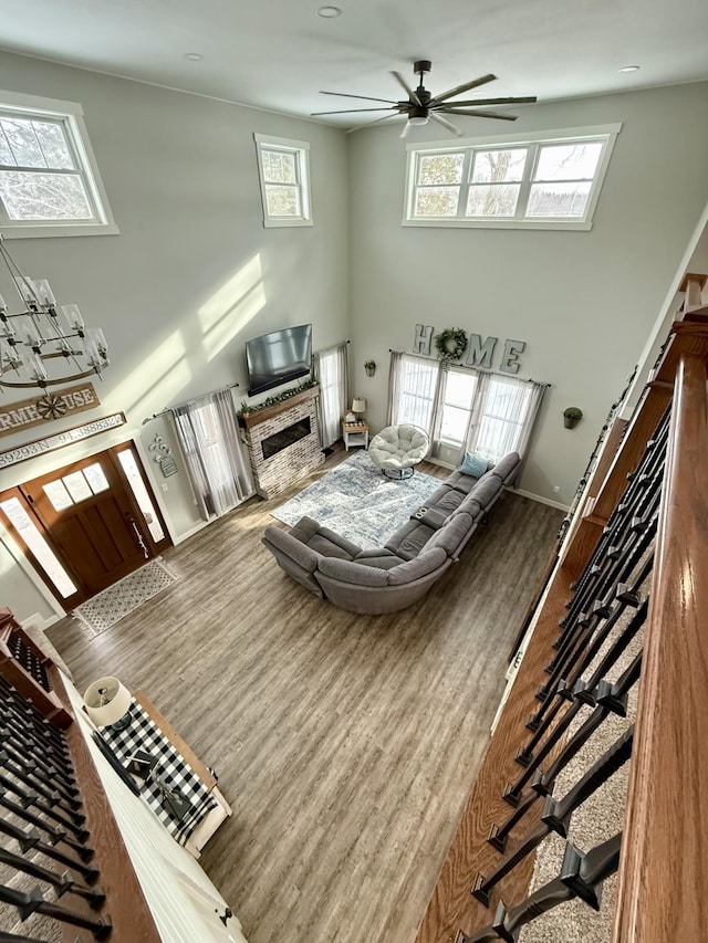 living room featuring ceiling fan, wood-type flooring, and a towering ceiling